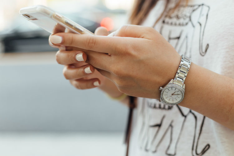 A woman on her phone enjoying a chiropractor's content marketing plan.