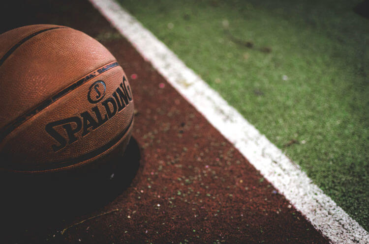 A basketball on the court of someone trying to get sports chiropractic certifications