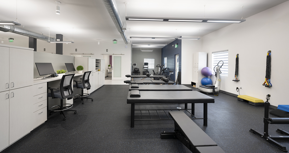 2A: This example includes an open, active PT area positioned close to the daylight with high contrast between the black rubber floor and white walls. Plus, there's adequate storage.